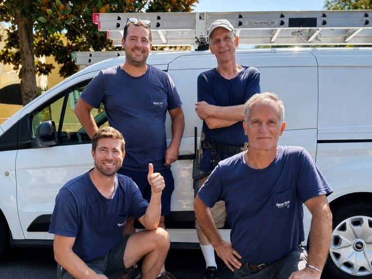 Squeaky Clean crew members smiling beside their van and ladder