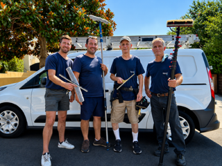 Four Squeaky Clean crew members ready for a job with professional cleaning equipment