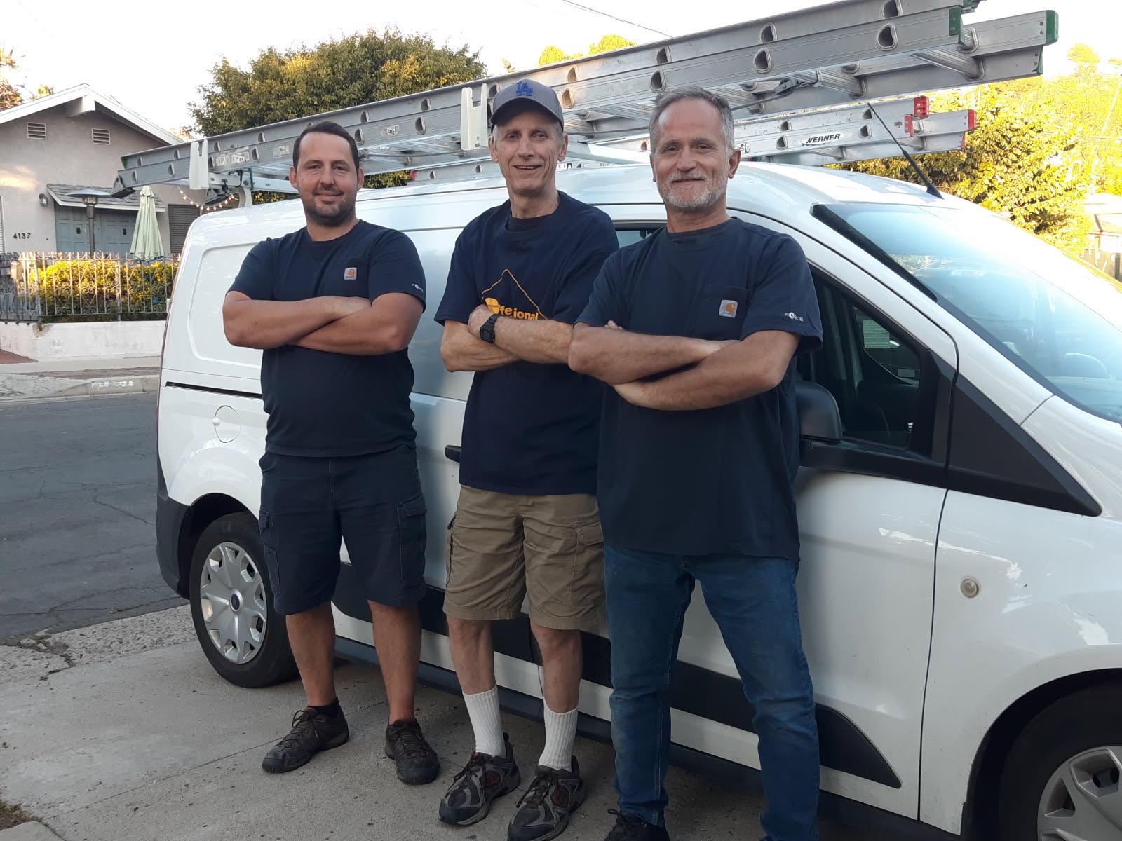 Three Squeaky Clean crew members standing beside their work van